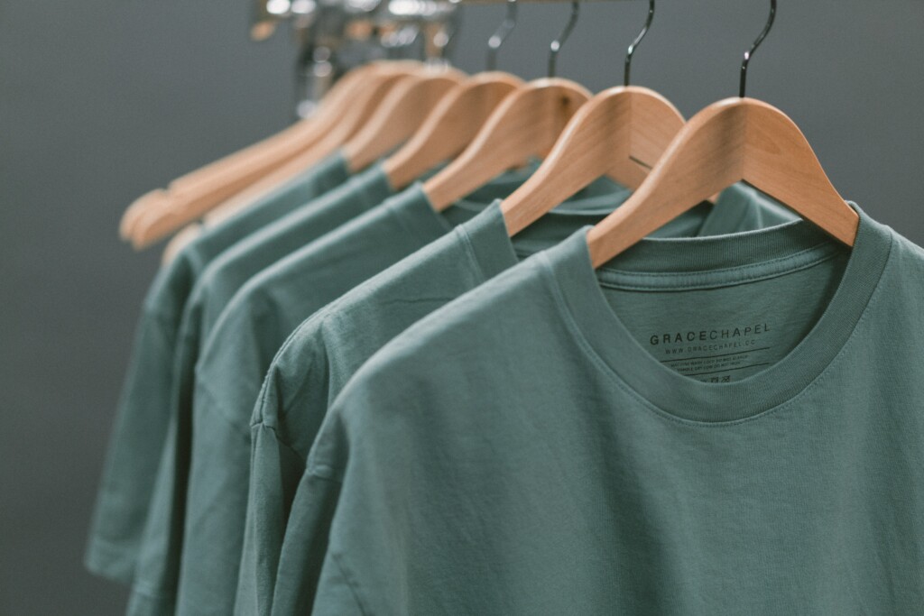 green T-shirts hanging on clothes hangers
