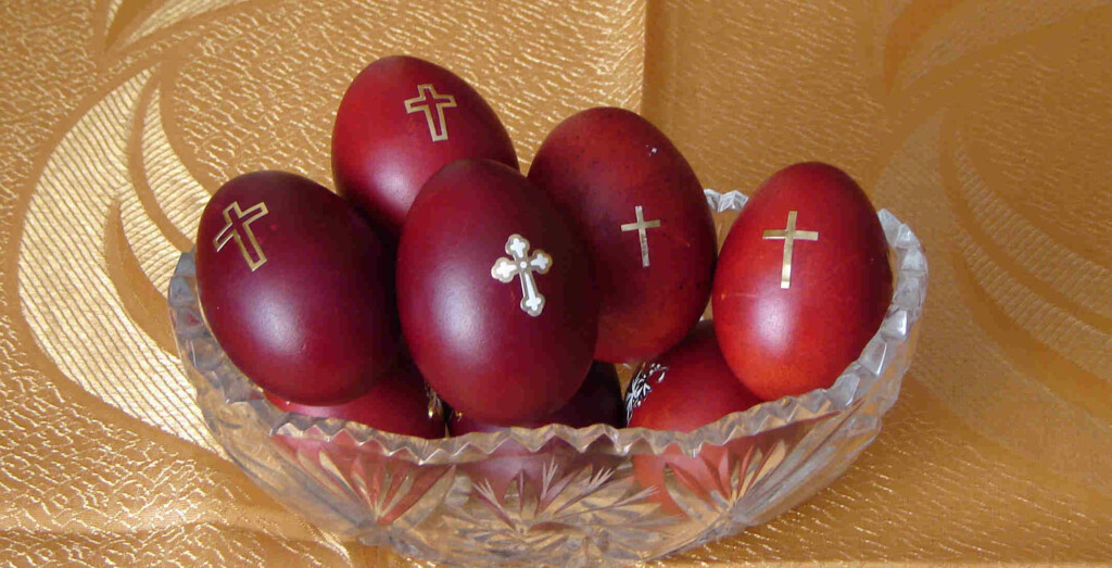 several red eggs with a picture of a cross painted on them in a glass jar