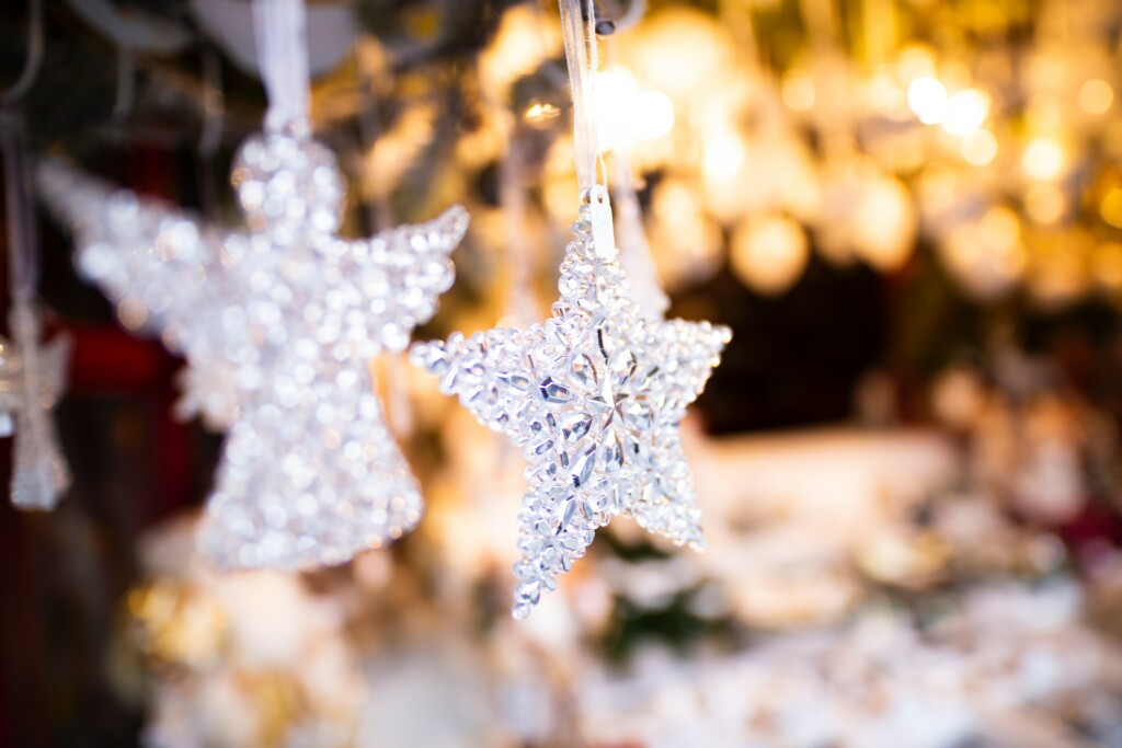 An image of angel and white star toppers hanging on a Christmas tree
