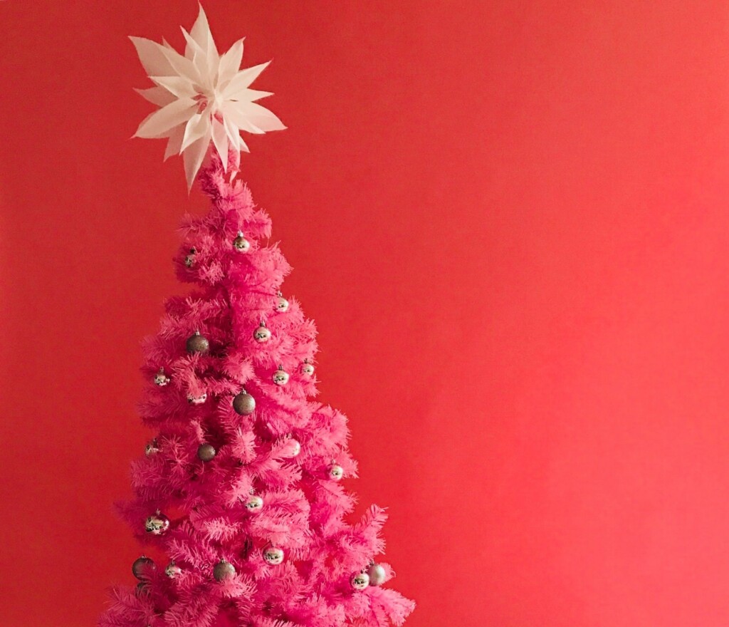 Pink Christmas tree decorated with white and silver balls.
