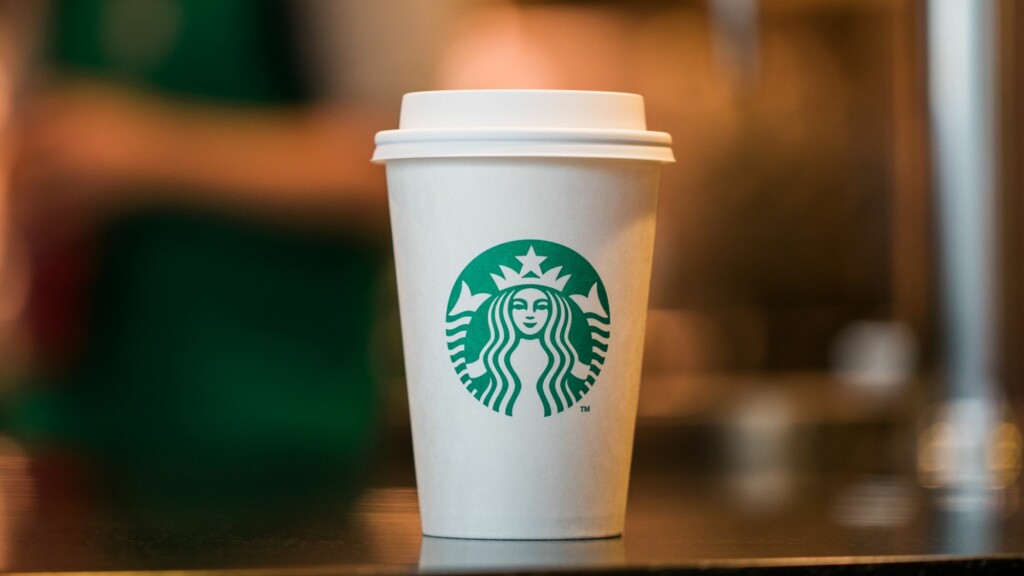 An image of a coffee cup with a green color Starbucks logo.