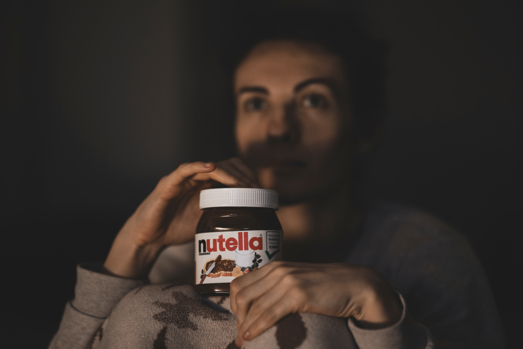 a picture of a girl holding a glass of Nutella in her hands.