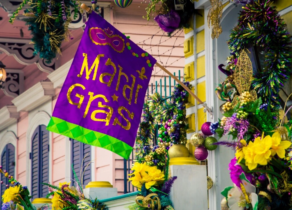 image of a purple flag with a green border with gold written on it Mardi Gras