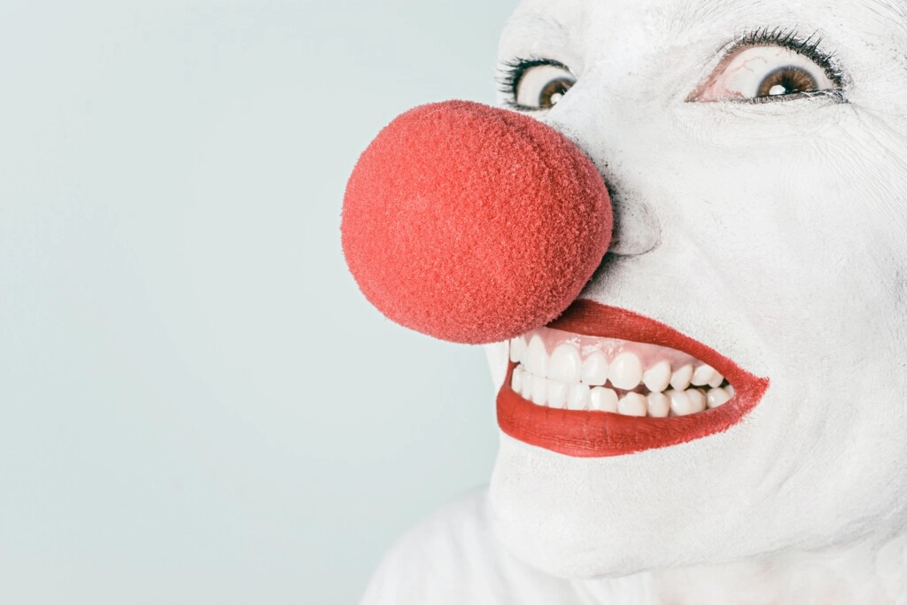 image of a clown with white face and red lips and nose