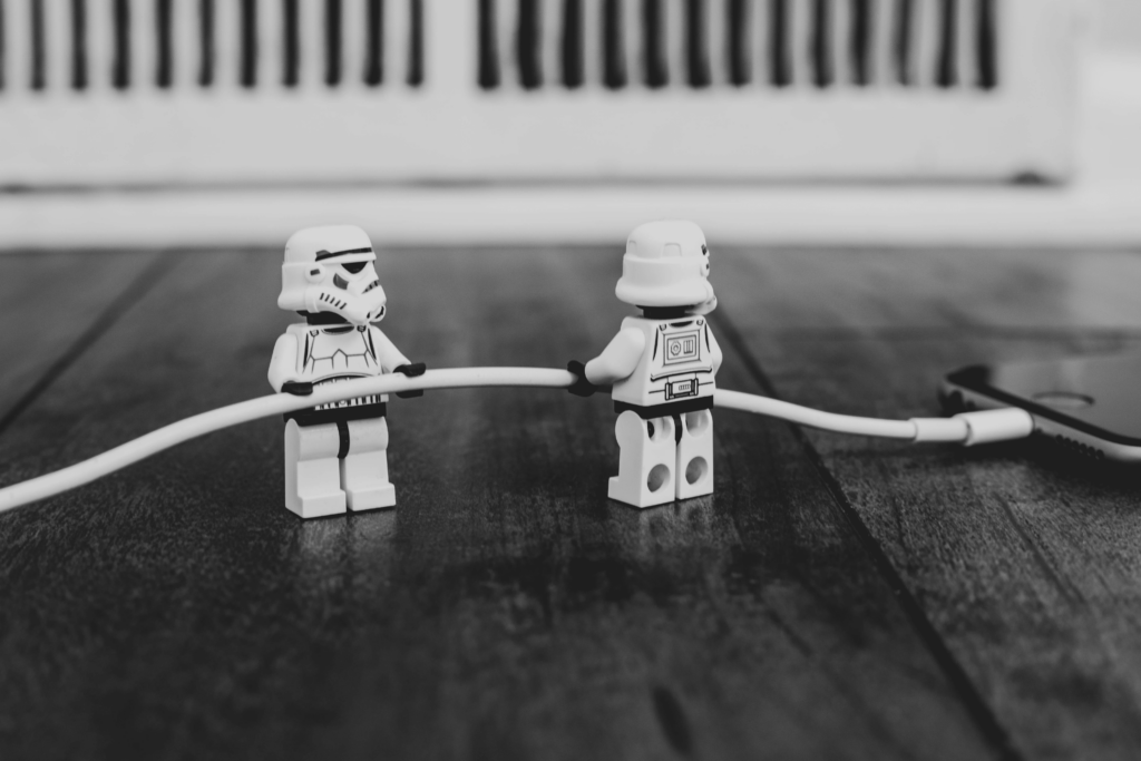 an image of two Legos from the Star Wars movie holding the phone charger cord.