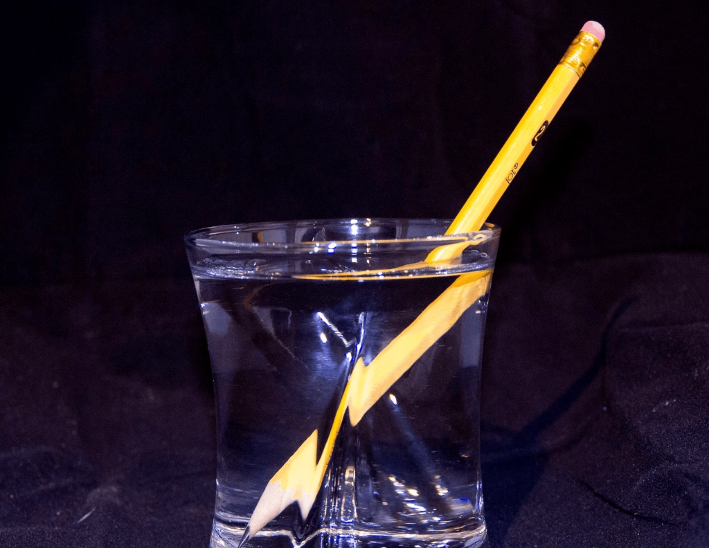 an image of a glass of water and a colored pencil inside it