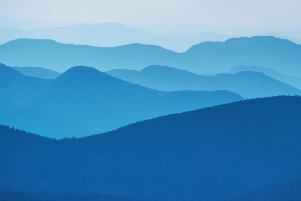 a picture of mountains with blue shadows