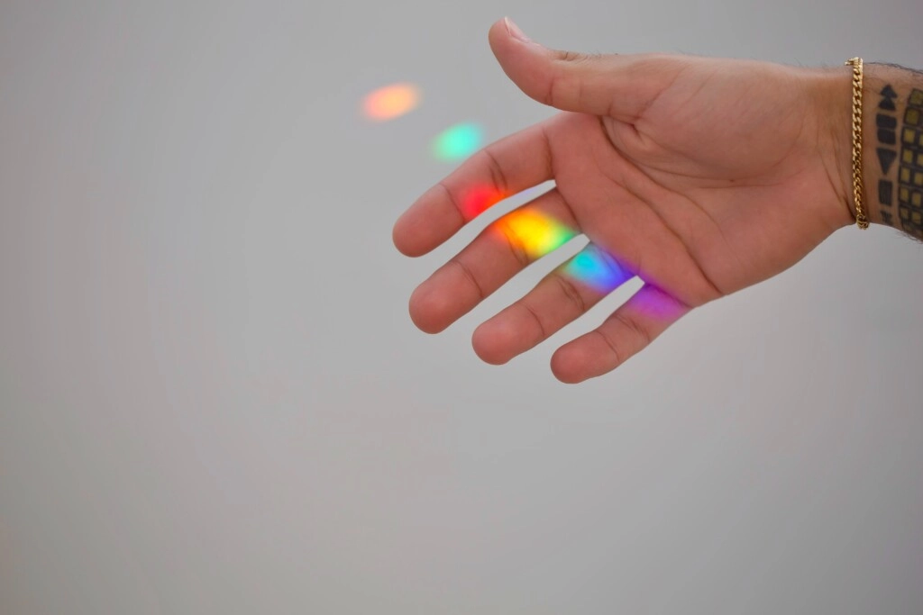 a hand with rainbow aura on it